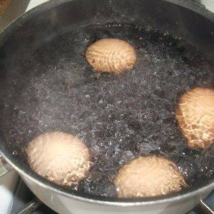 Trứng gà luộc chín, bóc sạch vỏ, cắt làm đôi, cho ra đĩa.